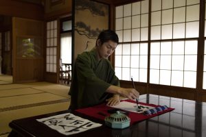 Seorang laki-laki jepang sedang belajar kanji